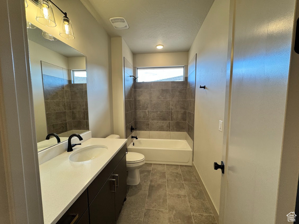 Full bath featuring toilet, bathing tub / shower combination, a healthy amount of sunlight, and vanity