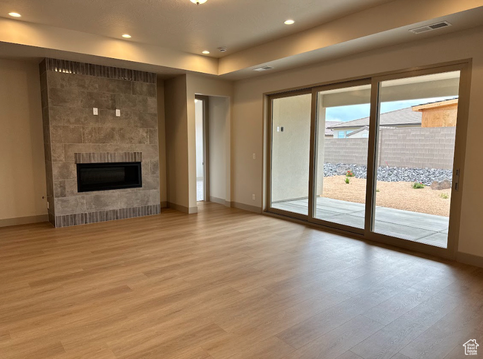 Unfurnished living room featuring recessed lighting, baseboards, and light wood-type flooring