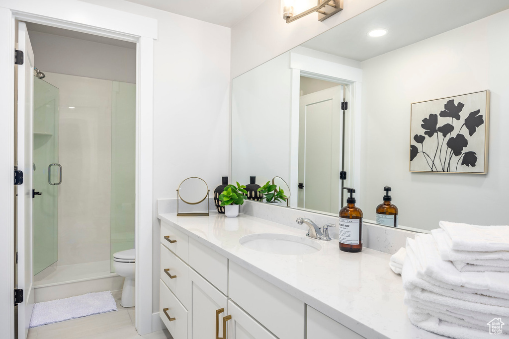 Bathroom featuring vanity, an enclosed shower, and toilet