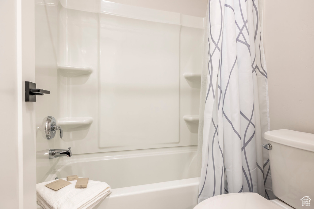 Bathroom featuring toilet and shower / bath combo