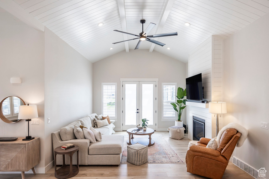 Living room featuring light hardwood / wood-style flooring, ceiling fan, high vaulted ceiling, french doors, and beamed ceiling