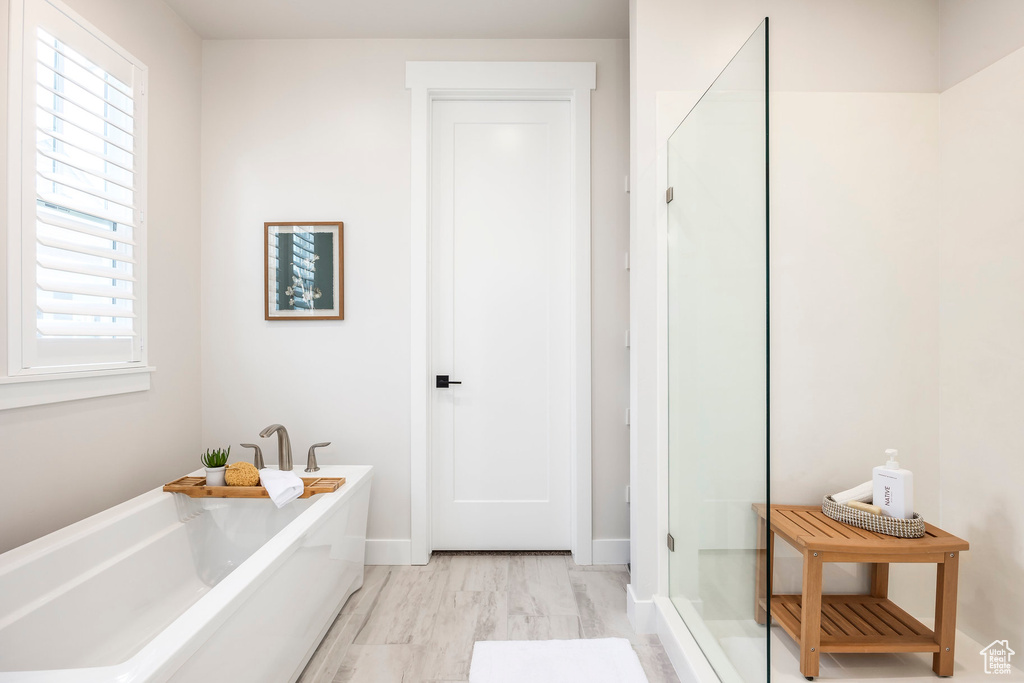 Bathroom with wood-type flooring and separate shower and tub