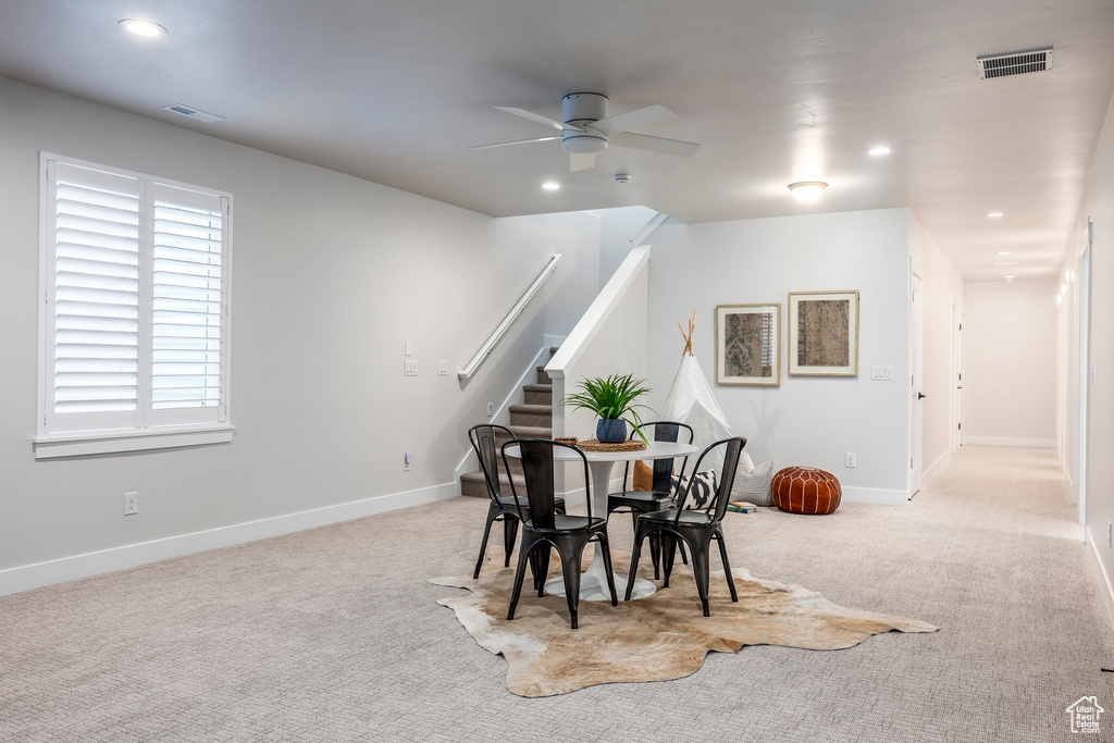Carpeted dining area with ceiling fan