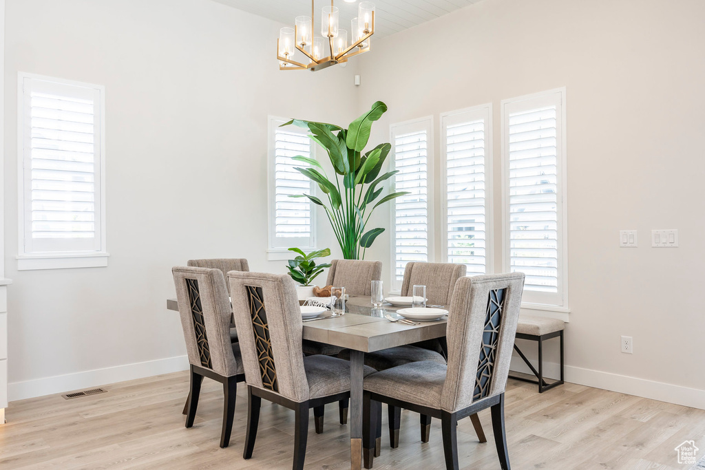 Dining room featuring an inviting chandelier and light hardwood / wood-style flooring