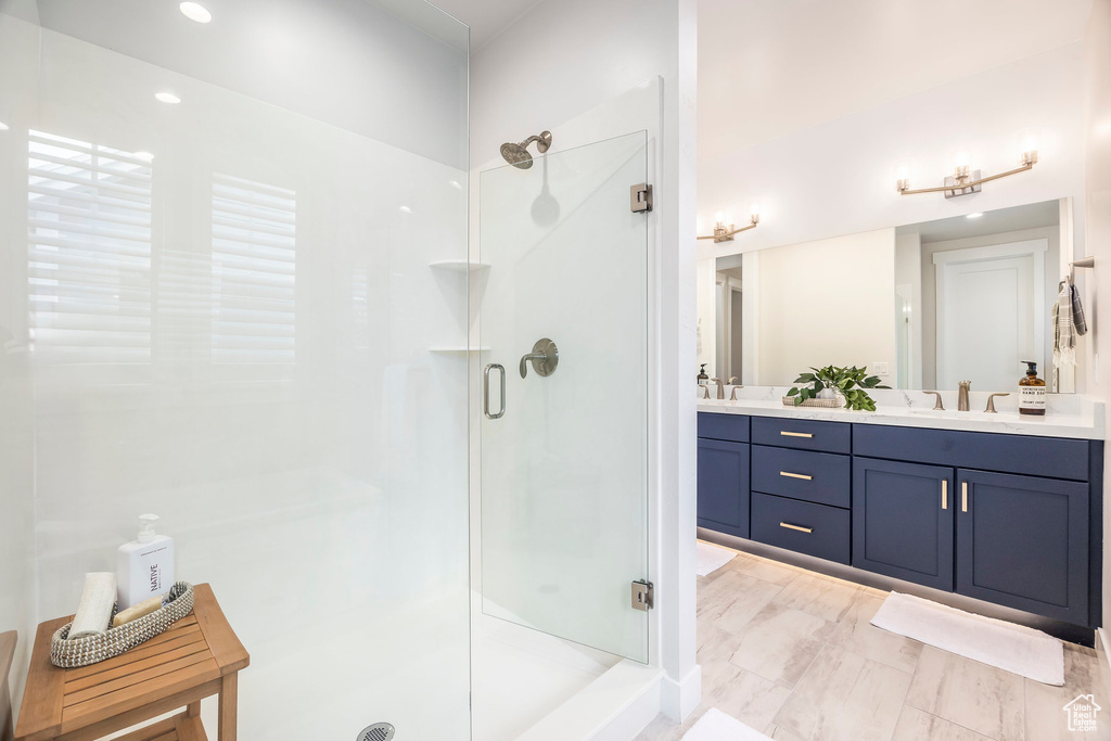 Bathroom featuring a shower with door and vanity