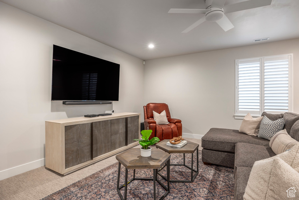 Carpeted living room featuring ceiling fan
