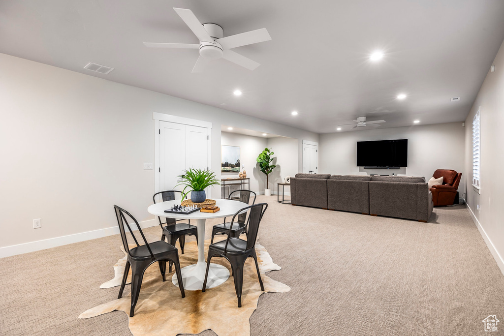 Carpeted dining space with ceiling fan