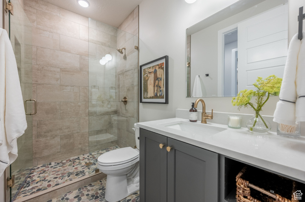 Bathroom featuring a stall shower, toilet, vanity, and recessed lighting