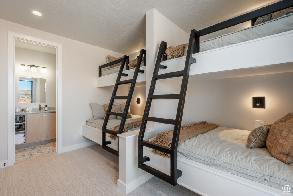 Carpeted bedroom with baseboards, recessed lighting, and ensuite bath