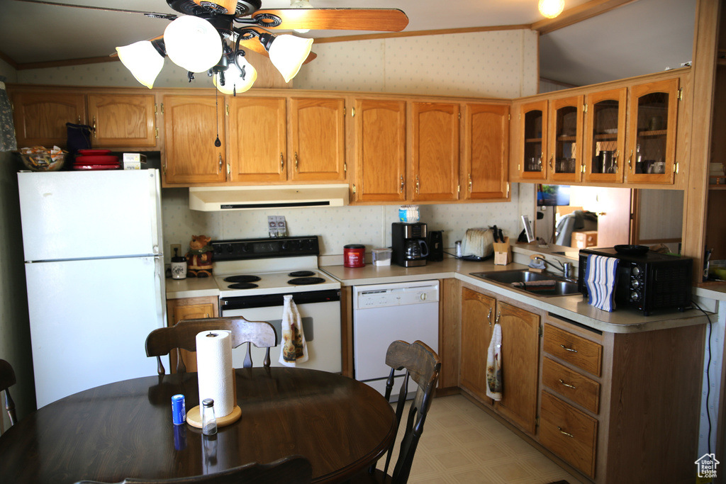Kitchen featuring lofted ceiling, sink, white appliances, and ceiling fan