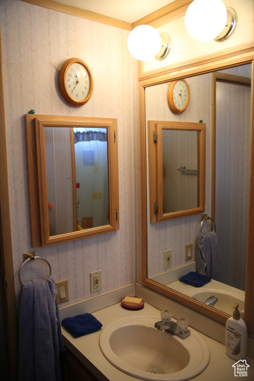 Bathroom featuring vanity and crown molding