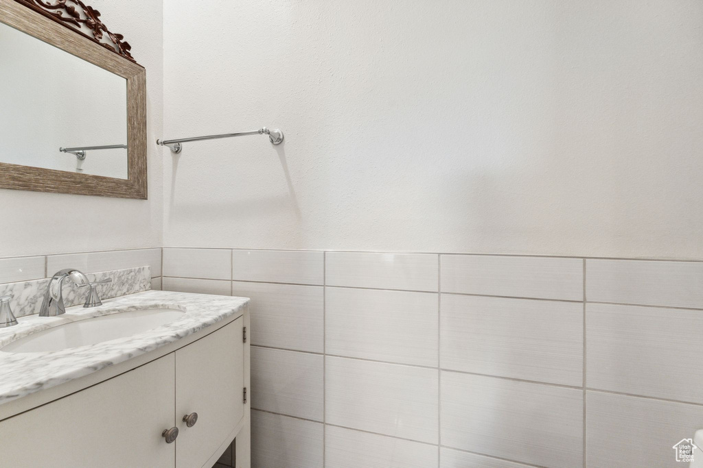 Bathroom with vanity and tile walls