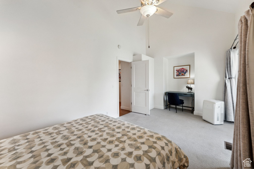 Unfurnished bedroom featuring carpet flooring, a high ceiling, baseboards, and a ceiling fan