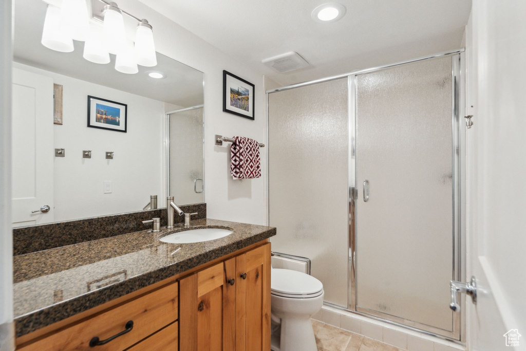 Full bathroom featuring toilet, vanity, a stall shower, recessed lighting, and tile patterned flooring