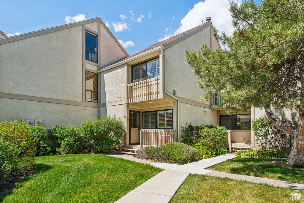 Townhome / multi-family property with stucco siding and a front lawn