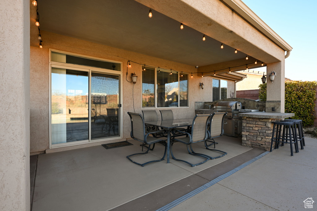 View of patio / terrace with an outdoor kitchen, area for grilling, and a bar