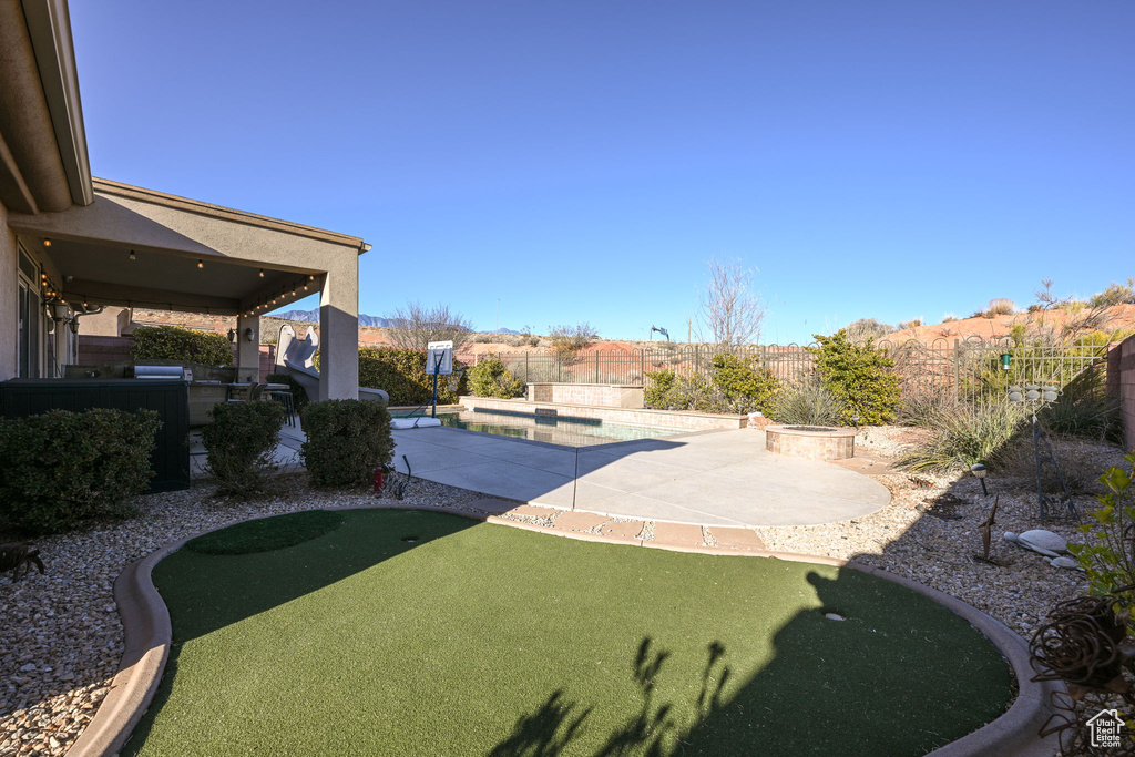 View of yard featuring a fenced in pool and a patio