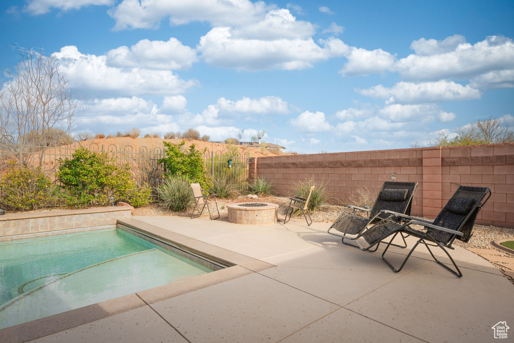 View of pool with a fenced in pool, a patio, a fire pit, and fence