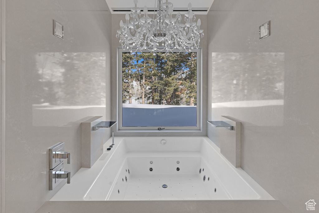 Bathroom featuring a bath and a chandelier