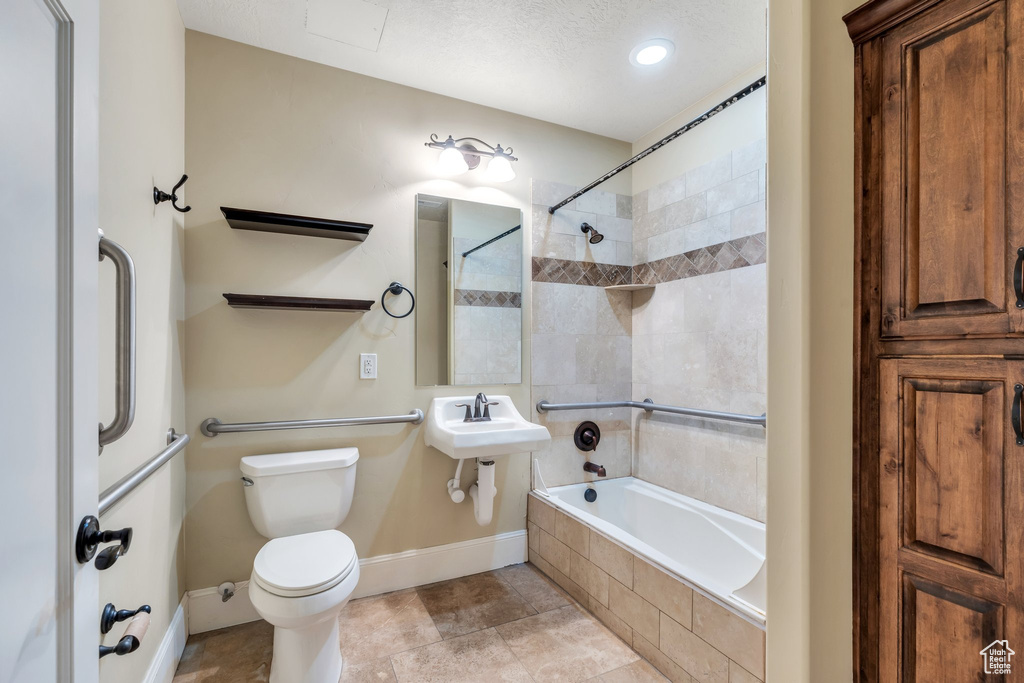 Bathroom with tiled shower / bath and toilet