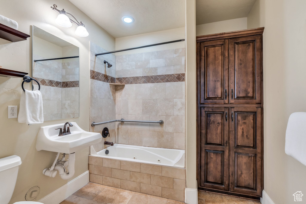 Bathroom with tiled shower / bath combo and sink