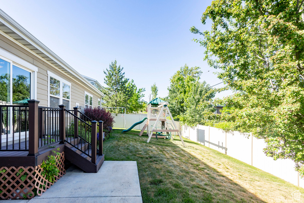 View of yard with a playground and a deck
