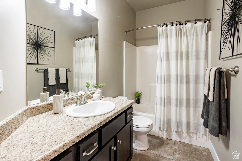 Bathroom with toilet, vanity, shower / bath combination with curtain, and tile patterned floors