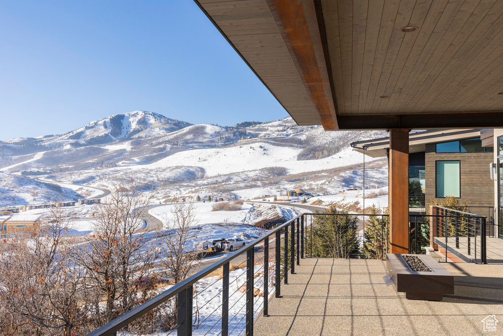 Snow covered back of property featuring a mountain view