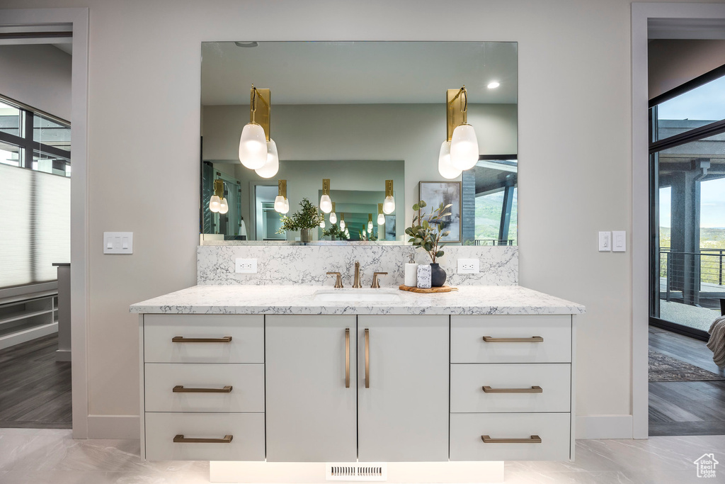 Bathroom with healthy amount of natural light, decorative backsplash, and vanity