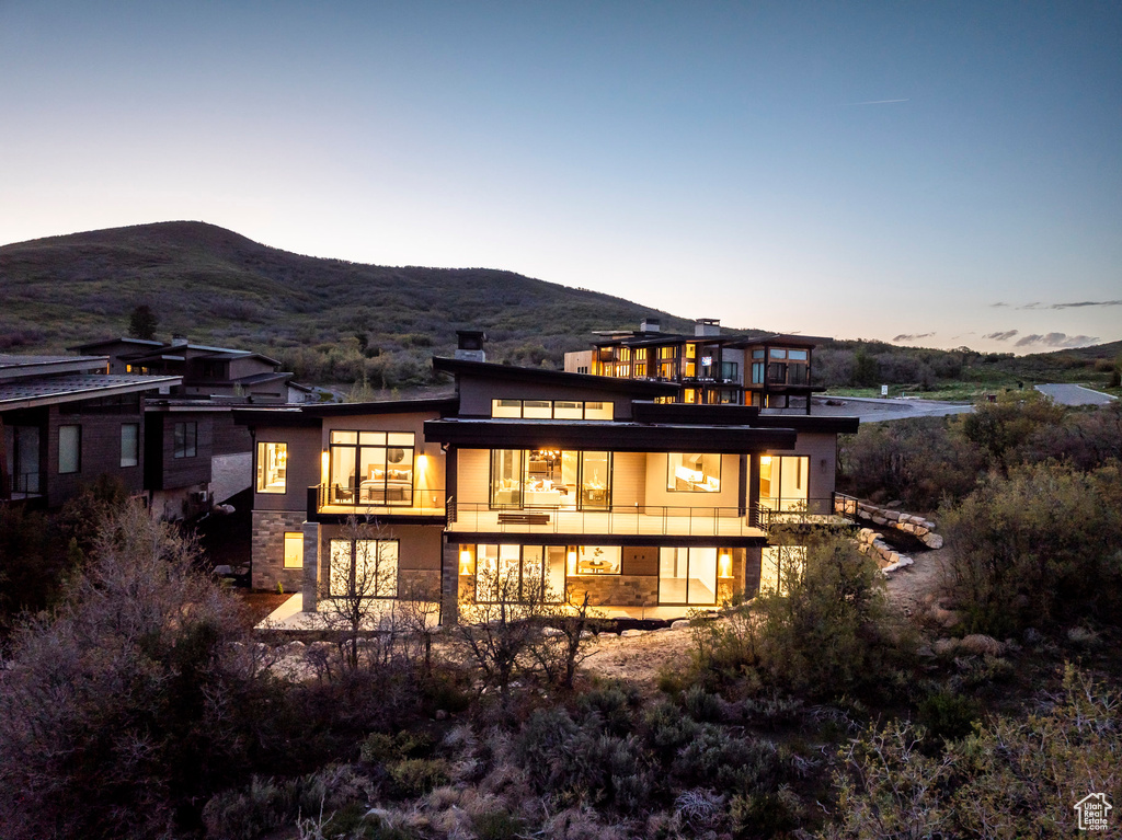 Rear view of property with a balcony, a mountain view, and stucco siding