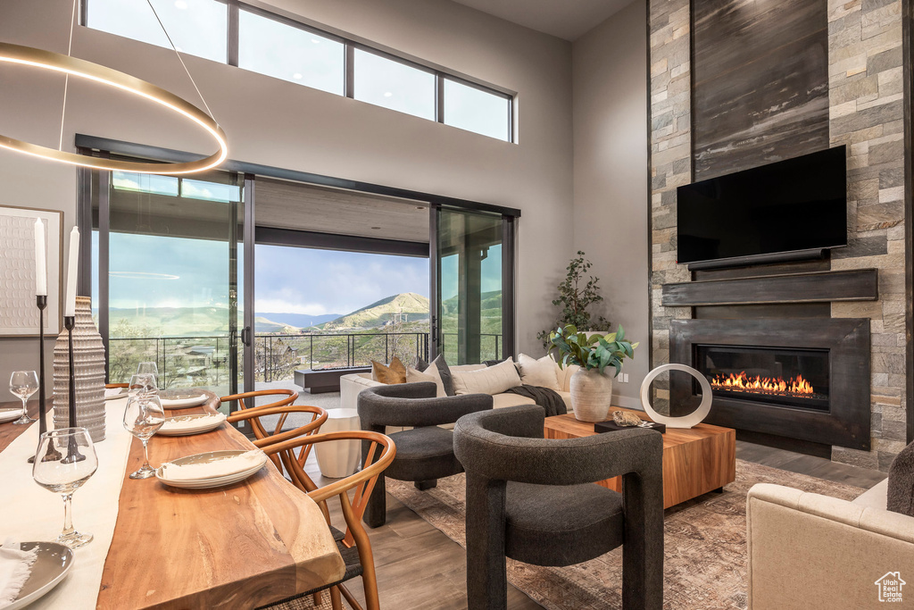 Living room with wood finished floors, a fireplace, and a towering ceiling