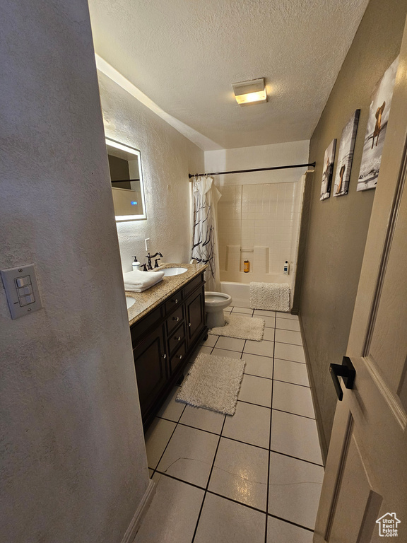 Full bathroom featuring toilet, a textured ceiling, vanity, shower / bathtub combination with curtain, and tile patterned flooring