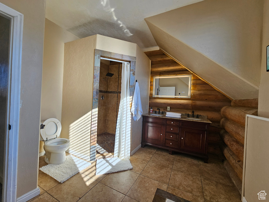 Bathroom with rustic walls, vanity, a shower, tile patterned floors, and toilet