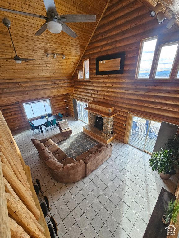 Living room with tile patterned floors, log walls, high vaulted ceiling, and wooden ceiling