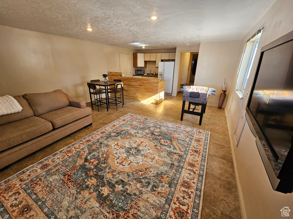 Tiled living room featuring a textured ceiling