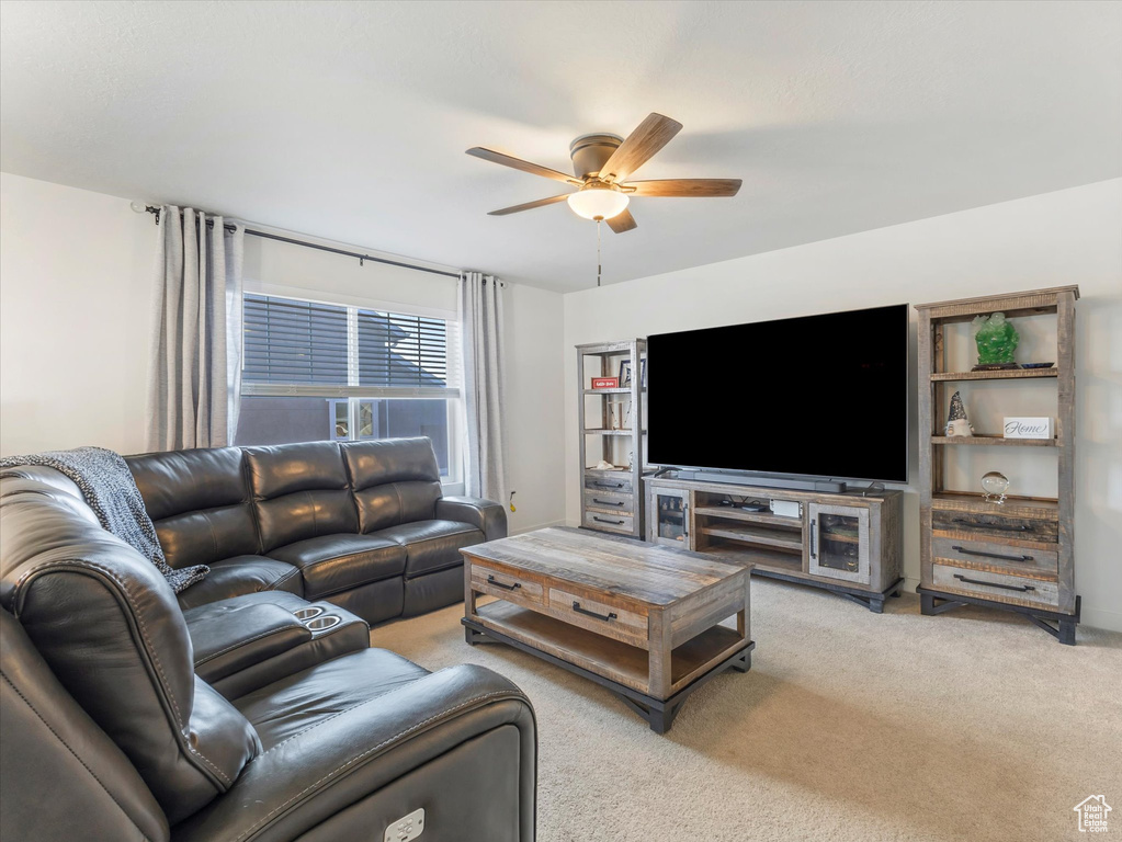 Living room featuring ceiling fan and light carpet