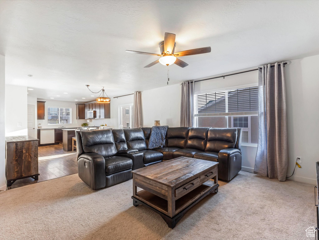 Living room featuring light colored carpet and ceiling fan