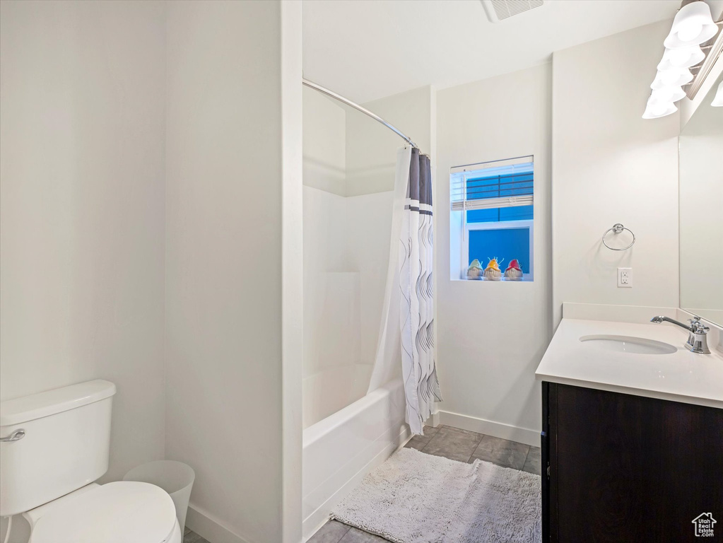 Full bathroom with toilet, vanity, and shower / bathtub combination with curtain