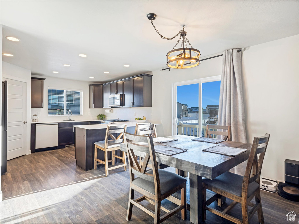 Dining area featuring sink, a notable chandelier, and dark hardwood / wood-style floors