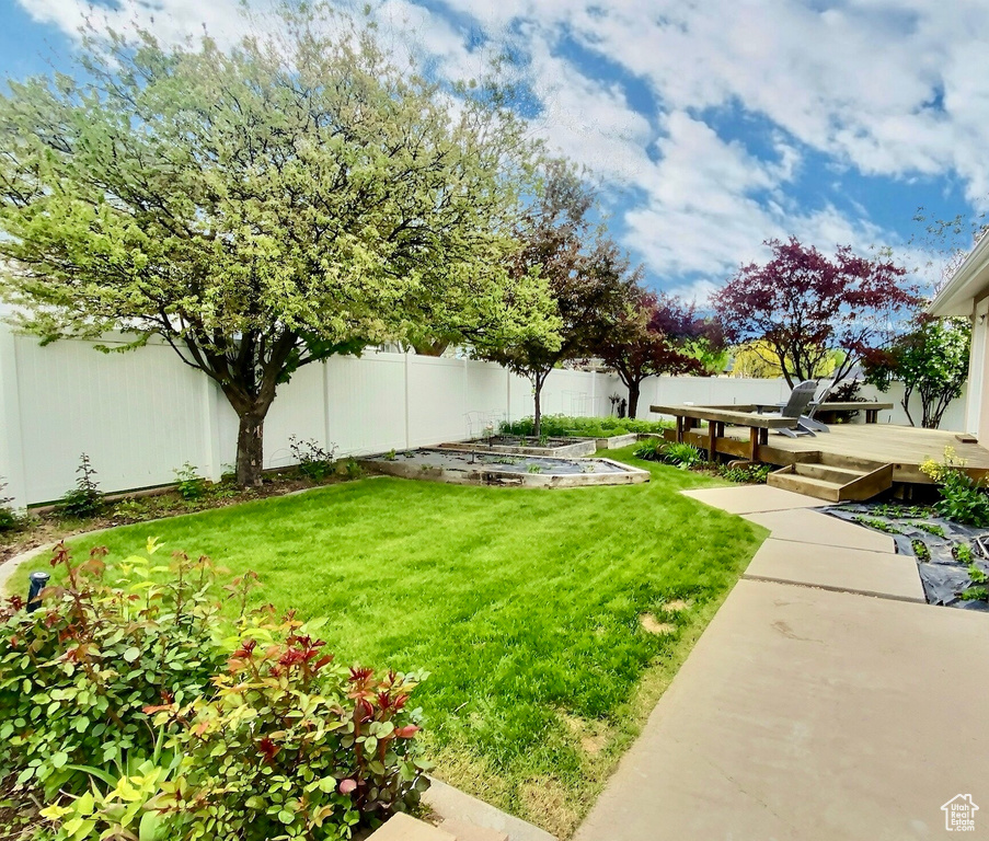 View of yard with a garden and a deck