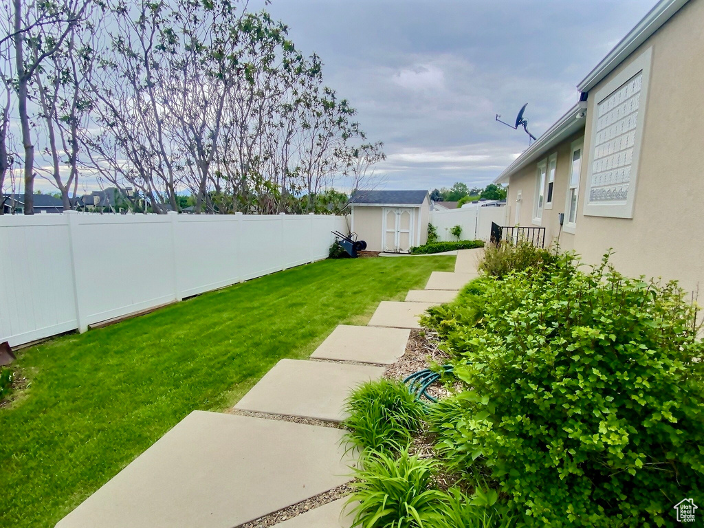 View of yard featuring a storage unit, an outbuilding, and a patio