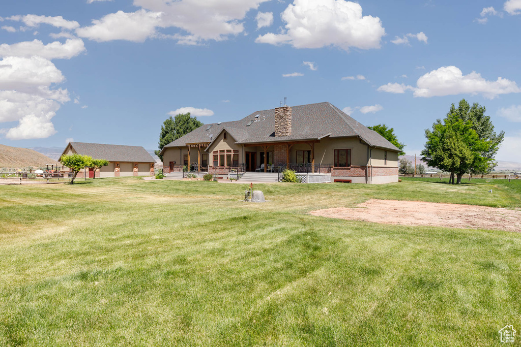 Rear view of house featuring a yard