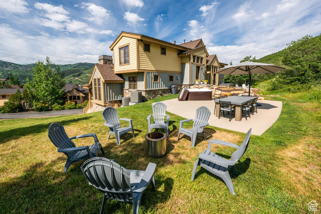 Back of house featuring central AC, a yard, and a patio