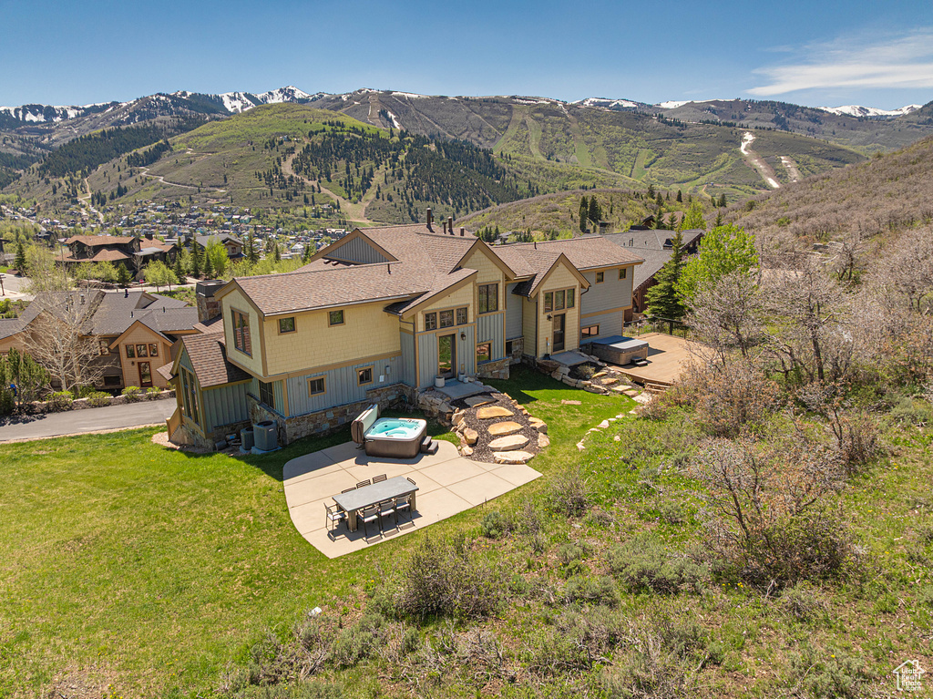 Aerial view of property and surrounding area featuring a mountain backdrop