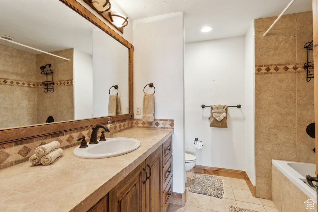 Full bathroom featuring tiled shower / bath, decorative backsplash, vanity, toilet, and tile patterned floors