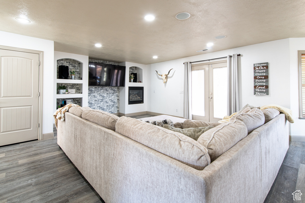 Living room with french doors, dark hardwood / wood-style flooring, and built in shelves
