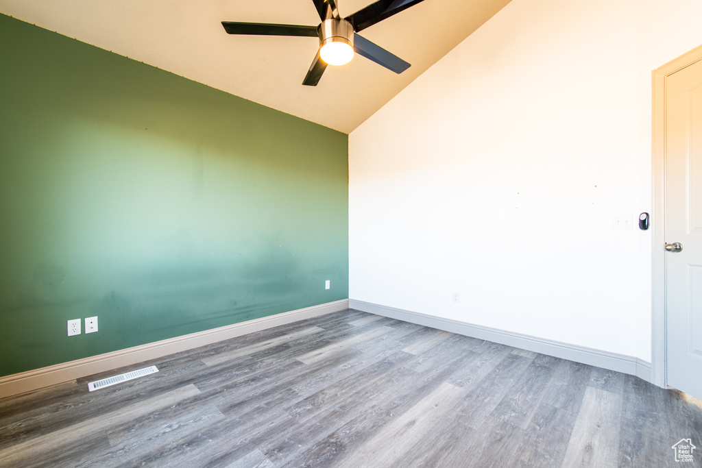 Unfurnished room featuring hardwood / wood-style flooring, ceiling fan, and lofted ceiling