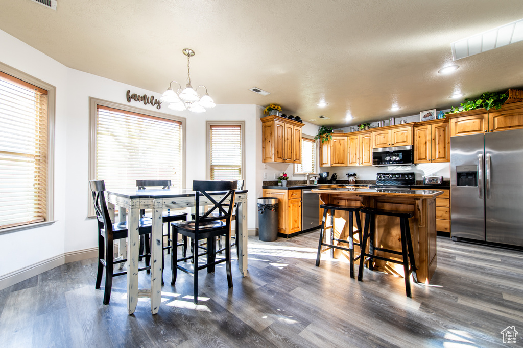 Dining space featuring wood-type flooring, sink, and an inviting chandelier