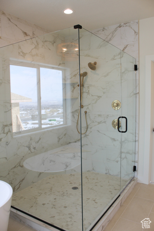 Bathroom with tile patterned flooring and shower with separate bathtub