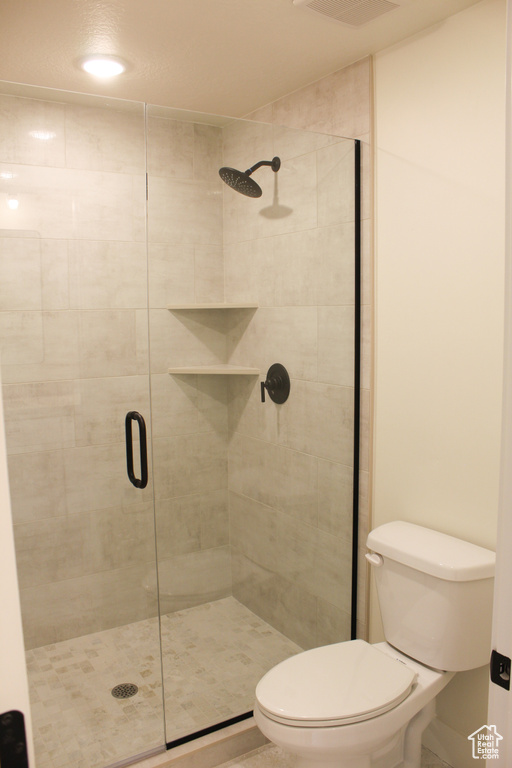 Bathroom with a shower with door and toilet